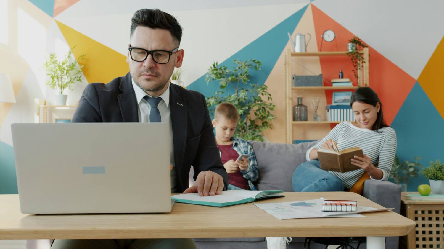 Man using a laptop with Family